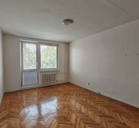 Living room in a two-room apartment with a wooden decor floor and a balcony.