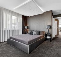 Bedroom in a 4-room apartment with a dark carpet and decorative walls.
