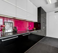A kitchen in a 4-room apartment with black cabinets and pink tiles.