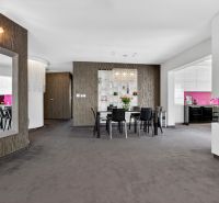 Dining room in a 4-room apartment with a mirror, fireplace, and kitchen with pink tiles.