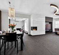 Living room in a 4-room apartment with a fireplace and a dining table with flowers.