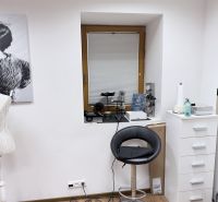 A chair and a side cabinet in commercial premises with a wooden decor floor.