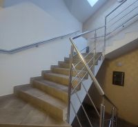 A staircase with stainless steel railing and natural light in commercial premises.