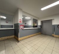 Interior of a building with a staircase and an elevator, warehouses and halls, tiles, light gray walls.