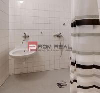 Bathroom in warehouses and halls with a sink, shower, and curtain.