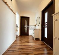 A hallway in a 3-room apartment with a wooden decor floor and white furniture.