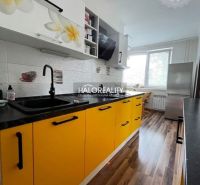 A kitchen with dominant yellow cabinets and a wooden decor floor in a 3-room apartment.