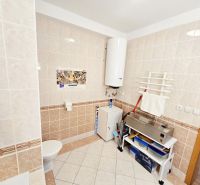 Bathroom in a 2-room apartment with furnishings and light tiles on the walls.