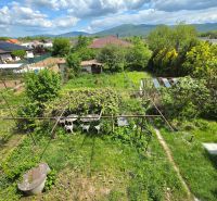 The garden of a family house on Lesná Street in Čaňa with a view of greenery and mountains.