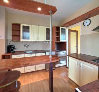 A kitchen in a family house with a wooden decor floor and practical furniture layout.