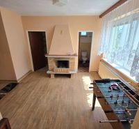 Living room with a fireplace, table football, and a wooden decor floor in a family house.