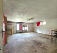A spacious room in a family house with a concrete floor and red details.