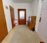 The entrance hall of a 3-room apartment with carpet flooring and wooden furniture.