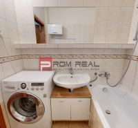 Bathroom with a washing machine, sink, and bathtub in a 3-room apartment.