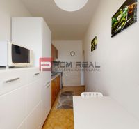 A kitchen in a 3-room apartment with appliances and furniture, tiled flooring, light-colored walls.