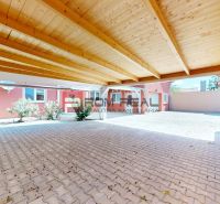 A shelter at a family house on Gútorská Street in Šamorín with a wooden ceiling and paving.