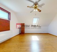 A room in a family house with a wooden decor floor, a skylight, and brick cladding.