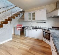 A kitchen with a wooden decor floor in a family house, modern equipment, and stairs.