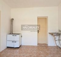 A room in a family house with ceramic tiles, a stove, and a sink.