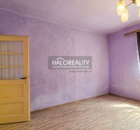 A room in a family house with purple walls and a wooden decor floor.