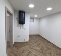 Commercial premises with white walls and wood-patterned flooring, equipped with a boiler.