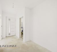 A hallway in a family house with white walls and white doors.