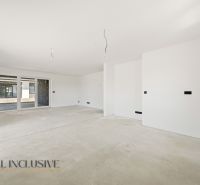 A spacious room in a family house with bare walls and a floor without covering.