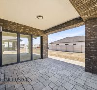 The terrace of a family house in Hviezdoslavov, lined with bricks and offering a beautiful view of the yard.