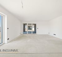 A spacious room in a family house with large windows and light walls.