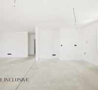 White room with a window and concrete floor in a family house.