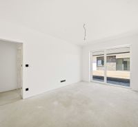 A spacious room in a family house with windows and white walls.