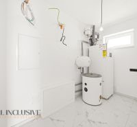 Technical room with a boiler in a family house with white walls and ceramic tiles.