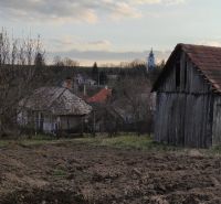 A rural barn and garden in the village of Nové Sady with a panorama of family houses.