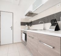 A kitchen with a wooden decor floor in a 3-room apartment.