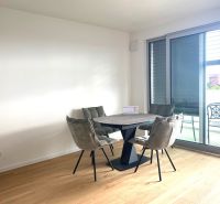 Dining table with chairs in an office with wood-patterned flooring.