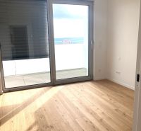 Office interior with wood-patterned flooring and a large window.