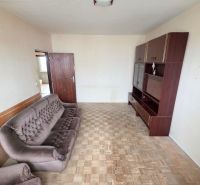 A room in a 3-room apartment with a brown sofa and furniture, floor with wooden decor.