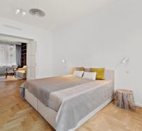 A bedroom with a bed and a wooden decor floor in a 4-room apartment.