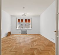 A bright room in a 4-room apartment with a wood-patterned floor and a large window.
