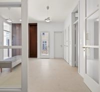 A bright entrance hall with tiles and glass doors in a 4-room apartment.