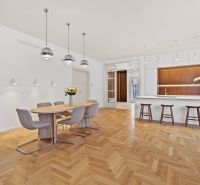 Dining room combined with kitchen in a 4-room apartment, floor with wood decor and hanging lamps.