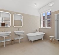 A stylish bathroom with a standalone bathtub and double sink in a 4-room apartment.