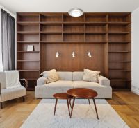 Living room in a 4-room apartment with a library and a wooden decor floor.