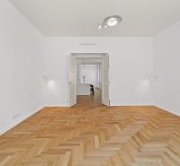 A room in a 4-room apartment with a wood-patterned floor and white walls.
