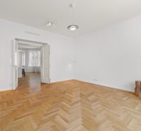 A spacious room with white walls and a floor with a wooden decor in a 4-room apartment.