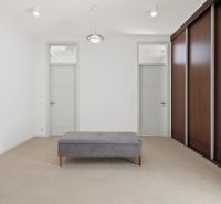 A bright room in a 4-room apartment with a large built-in wardrobe and a bench.