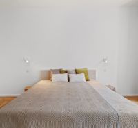 A bedroom with a light bed, wooden floor decor, and curtains in a 4-room apartment.