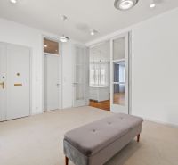 Interior of a 4-room apartment with a bench and light walls, floor with wood decor.