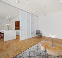 Interior of a 4-room apartment with a wooden decor floor and a kitchen island.