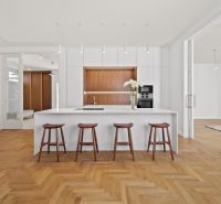 A kitchen in a 4-room apartment with an island and a wooden decor floor.